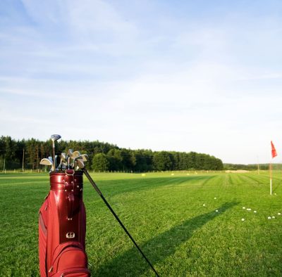 Golf gear on the golf field Golf gear on the golf field. Red flag in the background